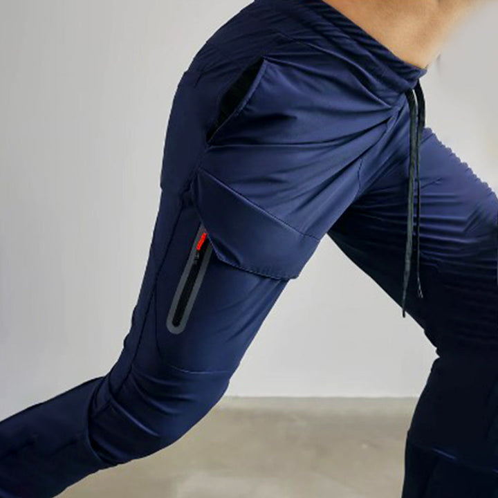 Donkerblauwe heren joggingbroek met zijzakken en trekkoord, ideaal voor sport en casual gebruik. Comfortabele pasvorm, hoogwaardige stof.
