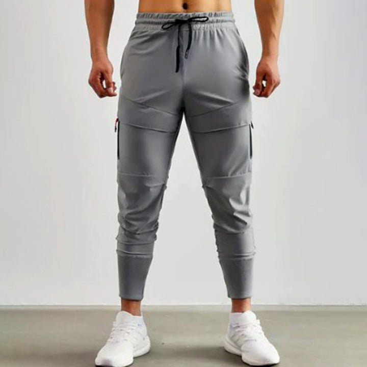 Grijze heren joggingbroek met zakken, elastische tailleband en trekkoord, sportieve stijl, comfortabele pasvorm, ideaal voor casual en sportieve activiteiten.