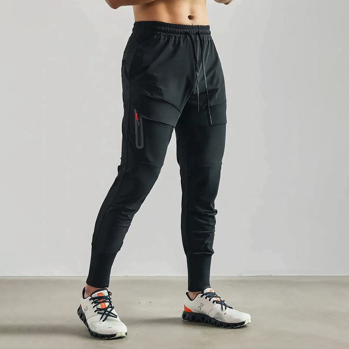 Zwarte heren joggingbroek met elastische tailleband, zijzakken en sportieve pasvorm. Ideaal voor fitness en casual wear. Comfortabele sportbroek.