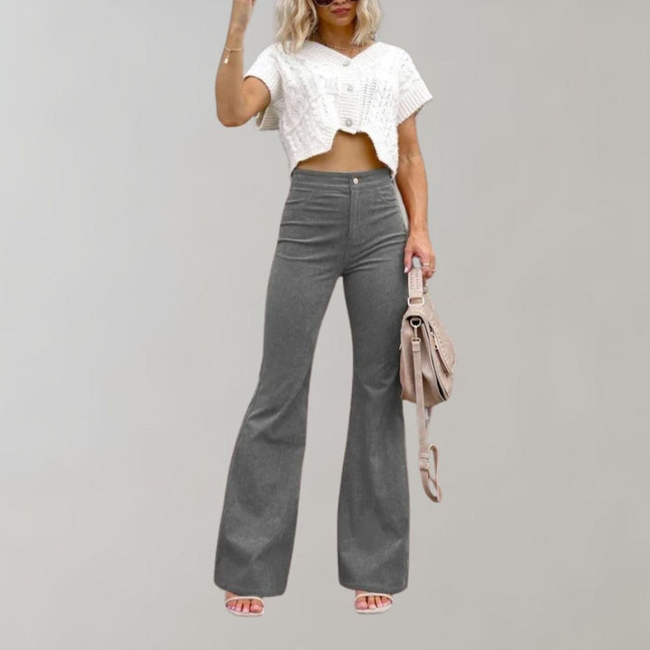 Grijze corduroy uitlopende broek voor dames, trendy en stijlvol, gecombineerd met een witte crop top. Perfect voor modieuze casual outfits.