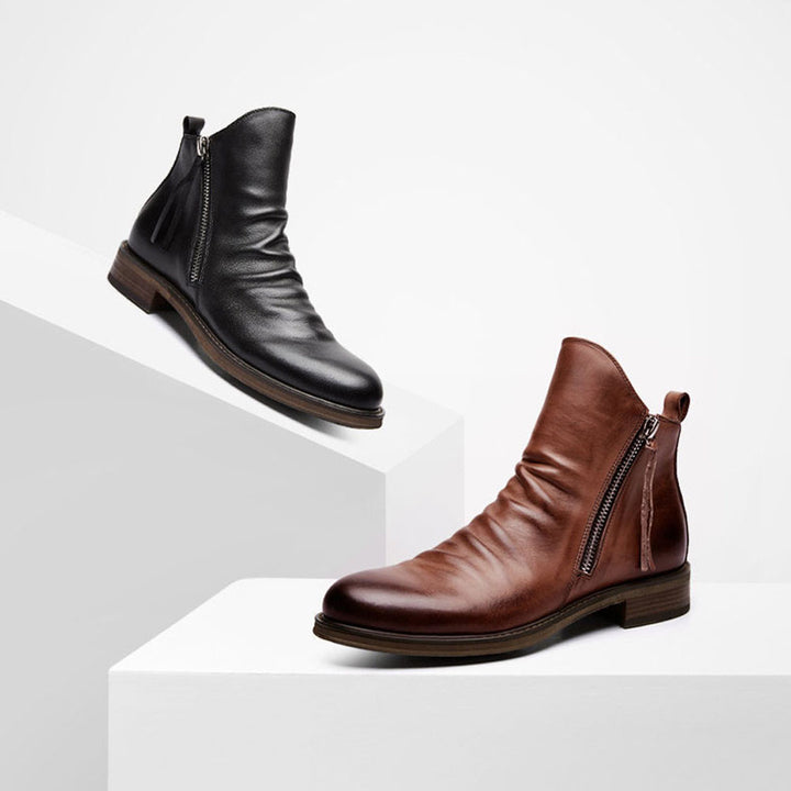 Twee leren enkellaarzen met rits, zwart en bruin, op witte achtergrond. Stijlvolle herenschoenen, casual en formeel, hoogwaardige kwaliteit.