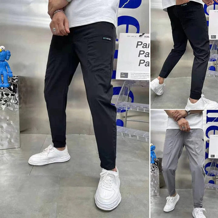 Man in sportieve joggers, verkrijgbaar in zwart, grijs en donkerblauw. Comfortabele pasvorm, ideaal voor casual en actieve outfits.