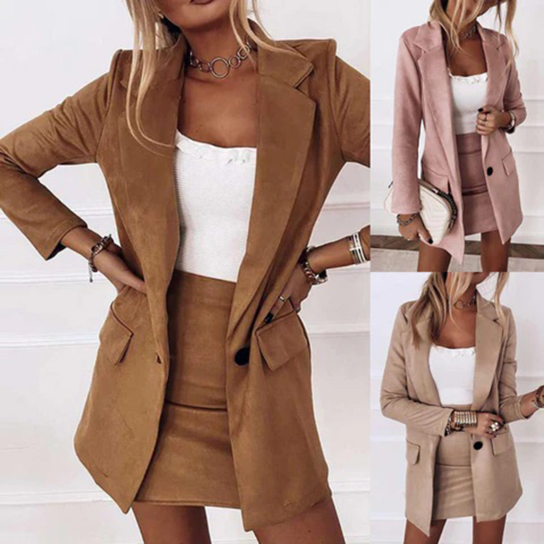 Vrouw in stijlvolle bruine blazer en rok set, met witte top. Modieuze dameskleding, perfect voor zakelijke en casual outfits. Verkrijgbaar in meerdere kleuren.