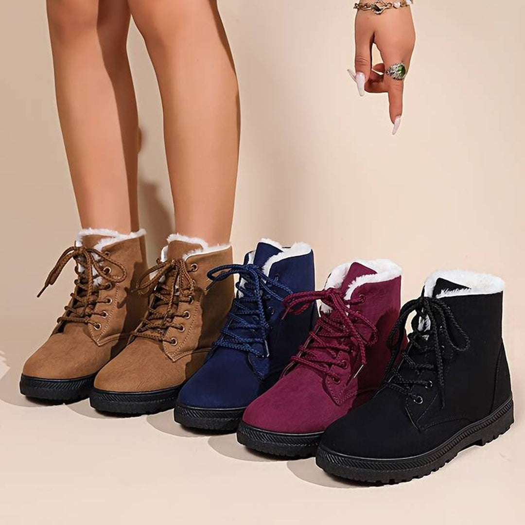 Vijf paar winterlaarzen met veters in bruin, blauw, bordeaux en zwart, gevoerd met witte bontvoering, op een beige achtergrond.