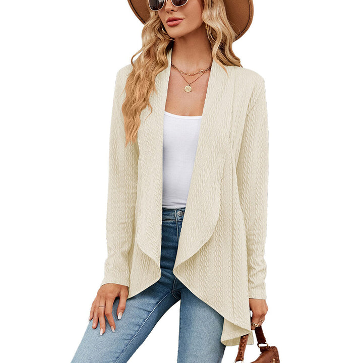 Vrouw in crèmekleurig vest, witte top en jeans, met hoed en zonnebril. Modieuze dameskleding, casual herfstoutfit, trendy stijl.