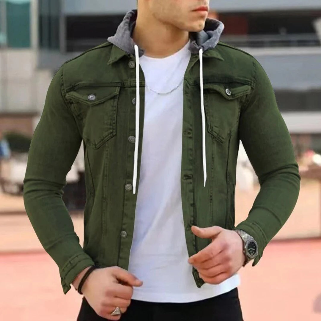 Man in legergroen jack met capuchon, witte T-shirt en zilveren ketting. Modieuze herenkleding, casual stijl, buitenomgeving.