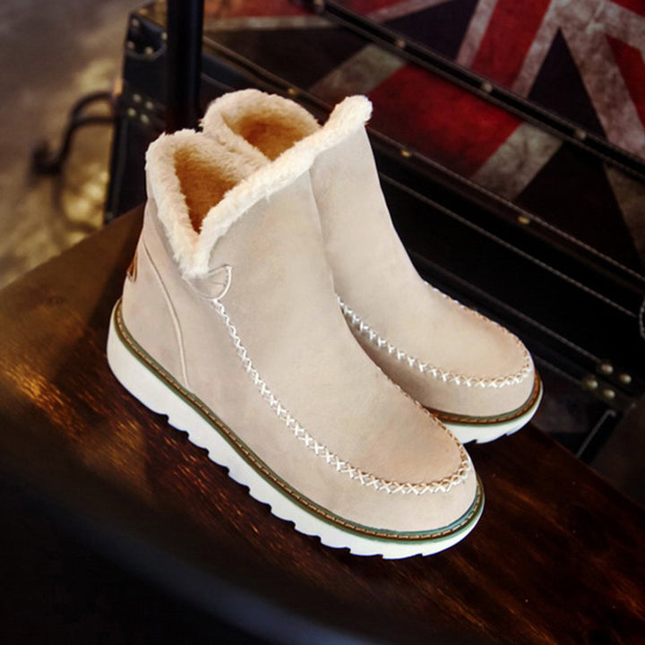 Beige suède laarzen met witte voering, dikke zool en stiksels, perfect voor wintermode. Comfortabele en stijlvolle dameslaarzen.