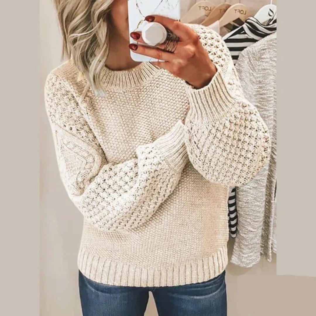 Beige gebreide trui met kabelpatroon, lange mouwen en ronde hals, gedragen door vrouw. Modieuze dameskleding, herfst-winter stijl.