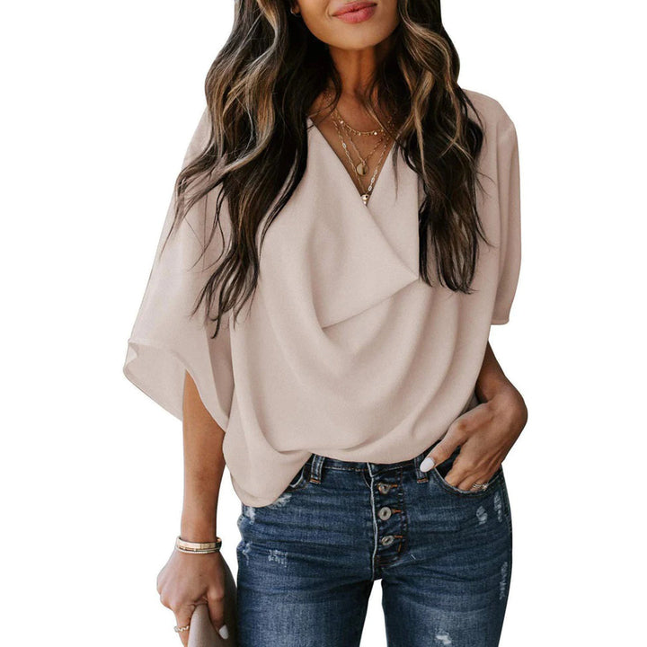 Beige damesblouse met korte mouwen, elegante V-hals en losse pasvorm, perfect voor casual en zakelijke outfits. Trendy damesmode top.