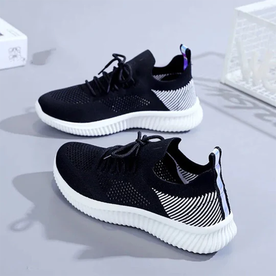 Zwarte sportschoenen met witte zool, ademend mesh bovenwerk, geschikt voor hardlopen en fitness. Stijlvol ontwerp, comfortabele pasvorm.