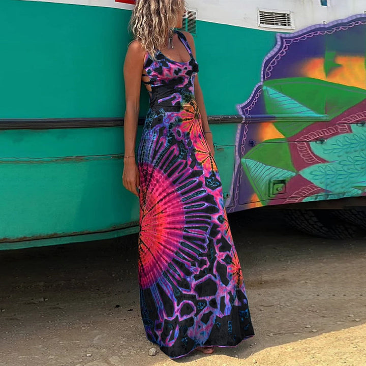 Vrouw in kleurrijke, lange jurk met psychedelisch patroon voor turquoise bus. Zomermode, bohemian stijl, strandkleding, festivaloutfit.