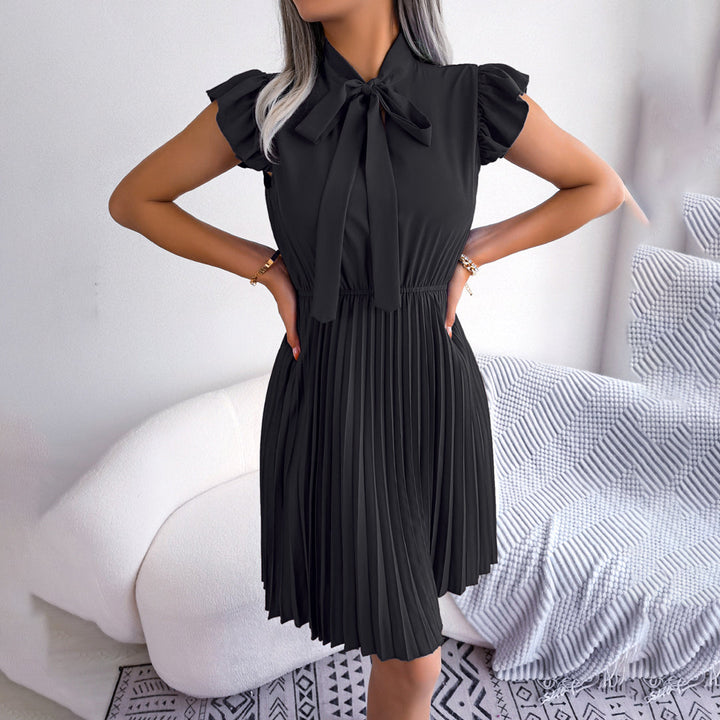 Zwarte geplooide jurk met strik, korte mouwen en elegante uitstraling, perfect voor formele gelegenheden. Modieuze dameskleding, stijlvolle outfit.