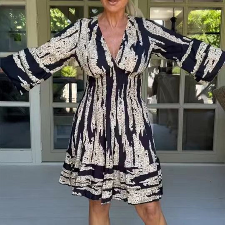 Zwart-wit gestreepte damesjurk met wijde mouwen, V-hals en abstract patroon, perfect voor casual zomeroutfits. Comfortabele en stijlvolle mode.