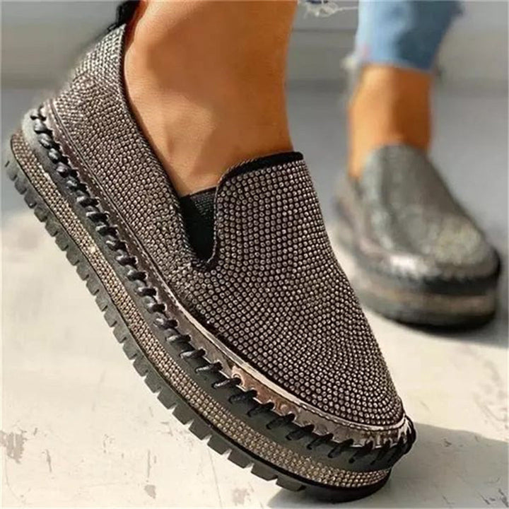 Zwarte damesschoenen met glinsterende strass steentjes, dikke zool en slip-on ontwerp. Trendy en comfortabele schoenen voor dagelijks gebruik.