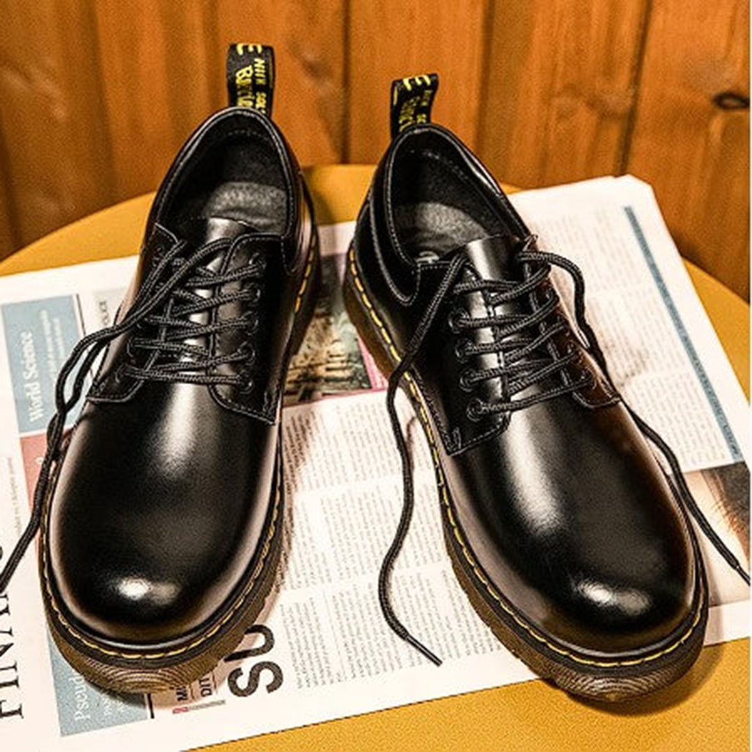 Zwarte leren herenschoenen met veters op een houten achtergrond, stijlvolle en duurzame schoenen voor dagelijks gebruik, modieus en comfortabel.
