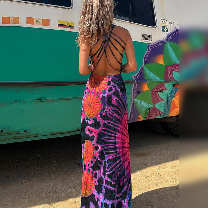 Vrouw in kleurrijke, lange zomerjurk met open rug, voor een busje met graffiti. Perfect voor bohemian mode, strandkleding, festivaloutfit.