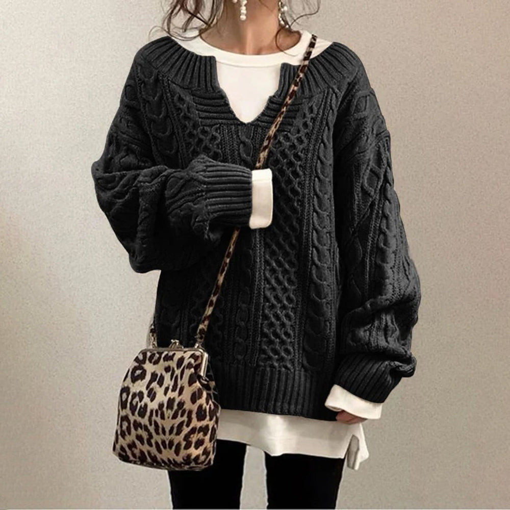 Zwarte kabeltrui dames, oversized pasvorm, gecombineerd met luipaardprint schoudertas. Modieuze herfst- en winterkleding, casual stijl.