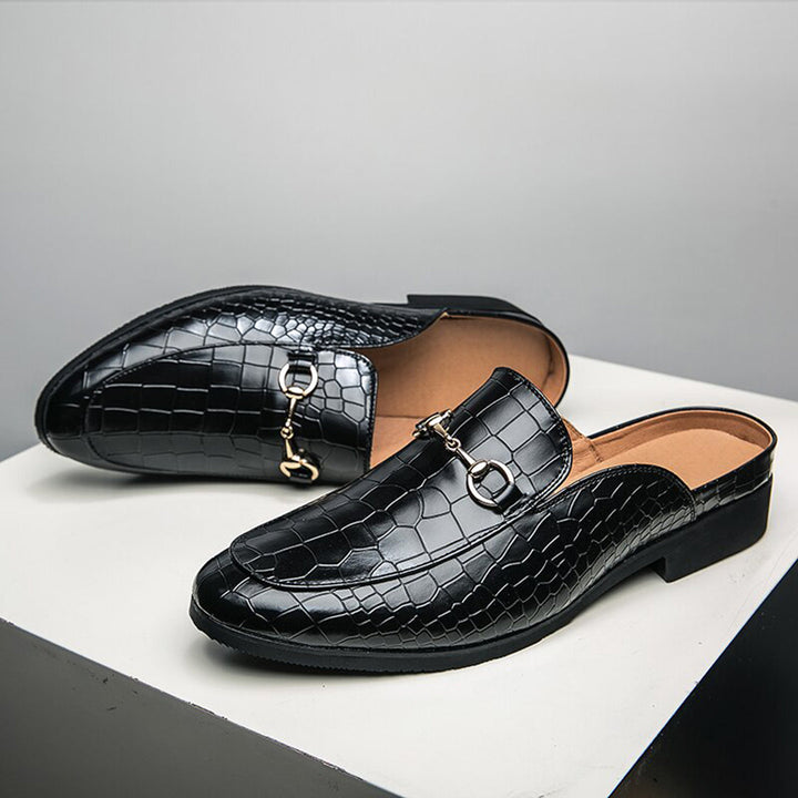Zwarte leren loafers met krokodillenprint en metalen gesp, stijlvolle herenschoenen, luxe design, perfect voor formele gelegenheden.