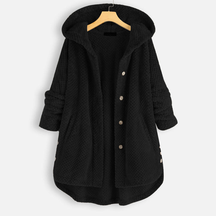 Zwarte fleece jas met capuchon, knopen en opgerolde mouwen, hangend aan een houten hanger. Comfortabele damesmode, winterkleding, trendy design.