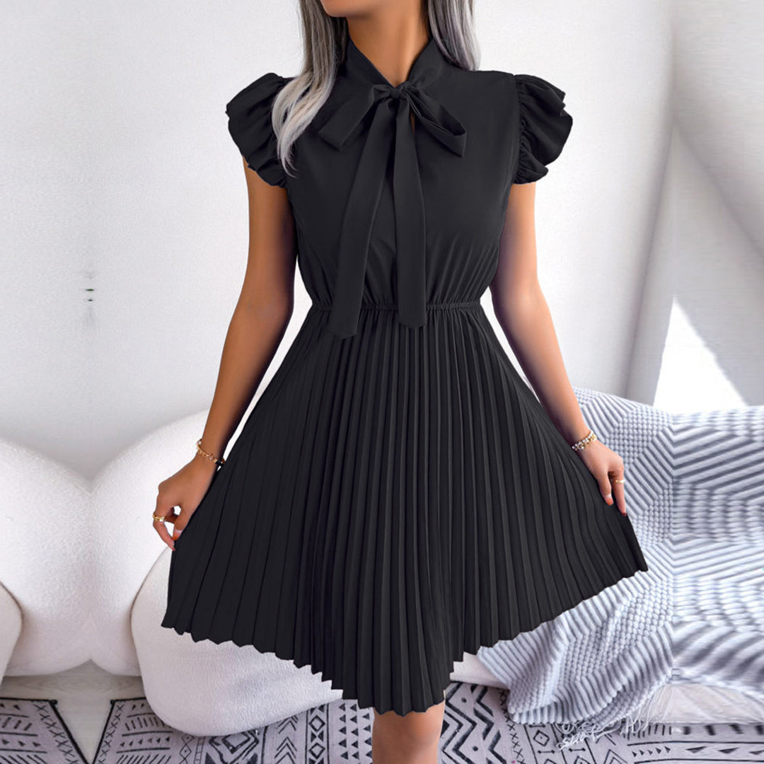 Zwarte geplooide jurk met strik, korte mouwen en elegante uitstraling. Perfect voor formele gelegenheden. Modieuze dameskleding.