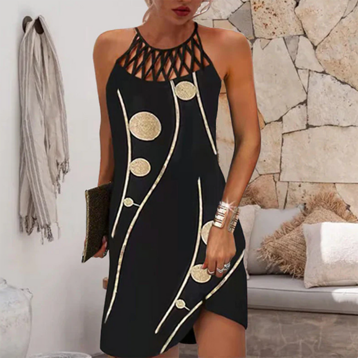 Zwarte zomerjurk met gouden cirkelpatroon, mouwloos en met opengewerkte halslijn. Perfect voor casual en feestelijke gelegenheden.