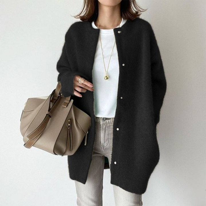 Vrouw draagt zwarte cardigan, witte top en beige tas. Modieuze dameskleding, casual stijl, herfstoutfit. Comfortabele en stijlvolle look.