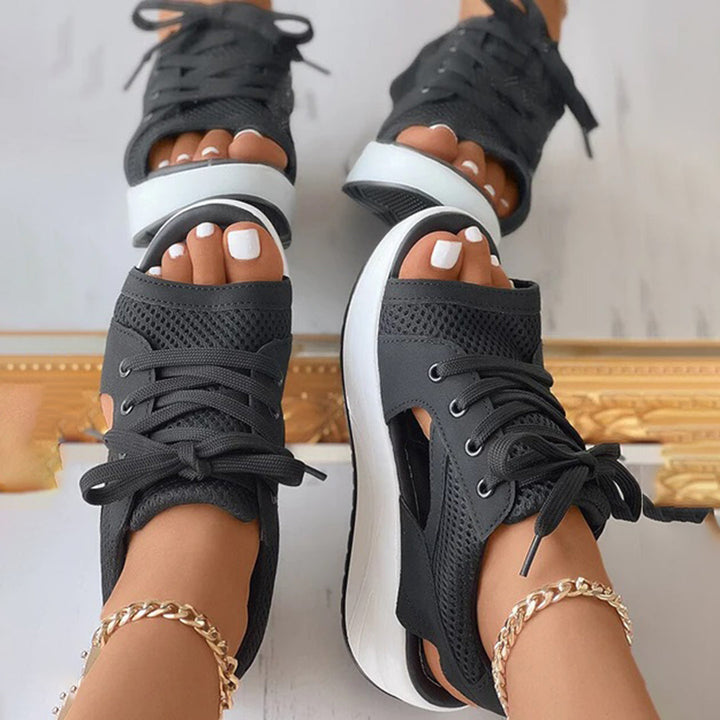 Zwarte dames sandalen met veters, open teen en dikke witte zool. Modieuze zomerschoenen, perfect voor casual en trendy outfits.