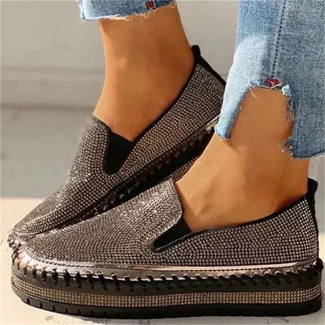 Zwarte glinsterende damessneakers met plateauzool, casual slip-on stijl, perfect voor dagelijks gebruik. Comfortabele en modieuze schoenen.