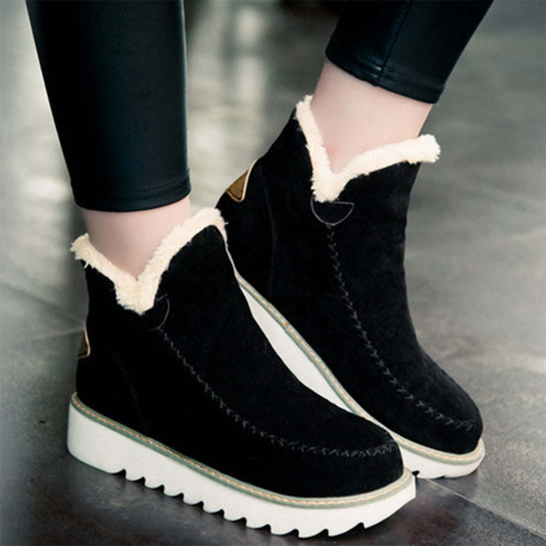 Zwarte suède enkellaarsjes met witte voering en dikke zool, ideaal voor wintermode. Comfortabele dameslaarzen, trendy en warm schoeisel.