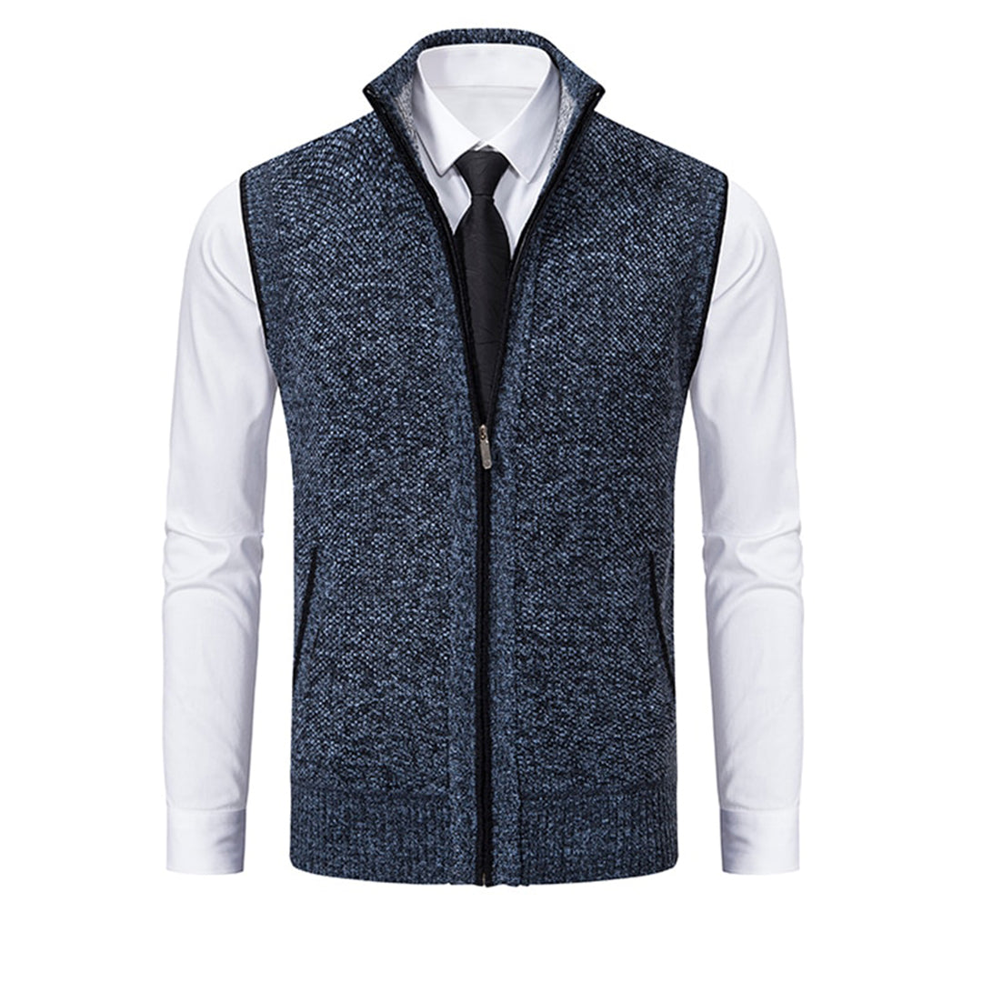 Blauw-grijs herenvest met ritssluiting, gedragen over een witte overhemd en zwarte stropdas. Stijlvolle, casual herenkleding.