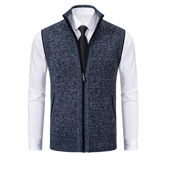 Blauw-grijs herenvest met ritssluiting, gedragen over een witte overhemd en zwarte stropdas. Stijlvolle, casual herenkleding.