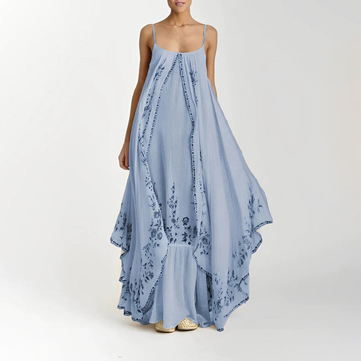 Vrouw in lichtblauwe maxi-jurk met bloemenprint, mouwloos en luchtig ontwerp. Perfect voor zomerse dagen. Elegante damesmode, casual stijl.
