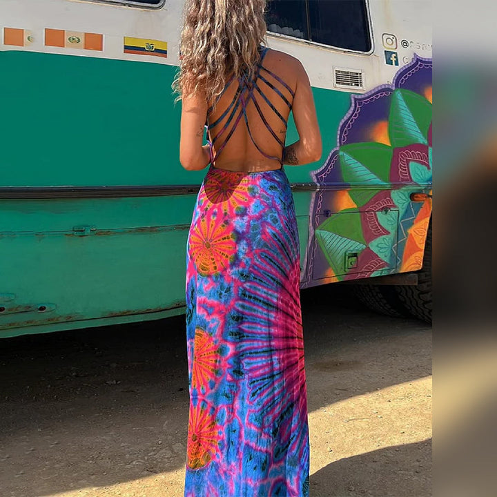 Vrouw in kleurrijke, lange zomerjurk met open rug en strappy details, voor een beschilderde bus. Perfect voor boho-chic strandmode.