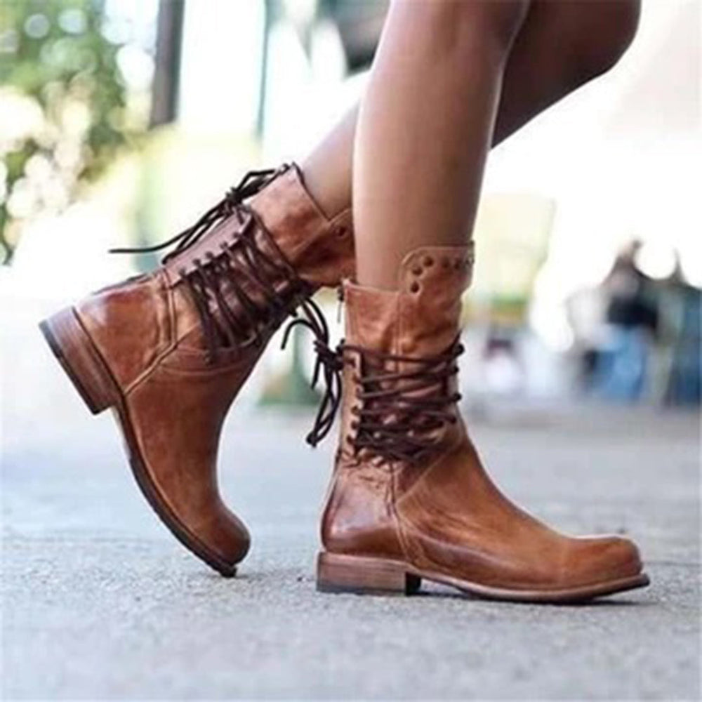Bruine leren laarzen met veters, gedragen door een persoon. Stijlvolle dameslaarzen, perfect voor herfstmode en casual outfits.