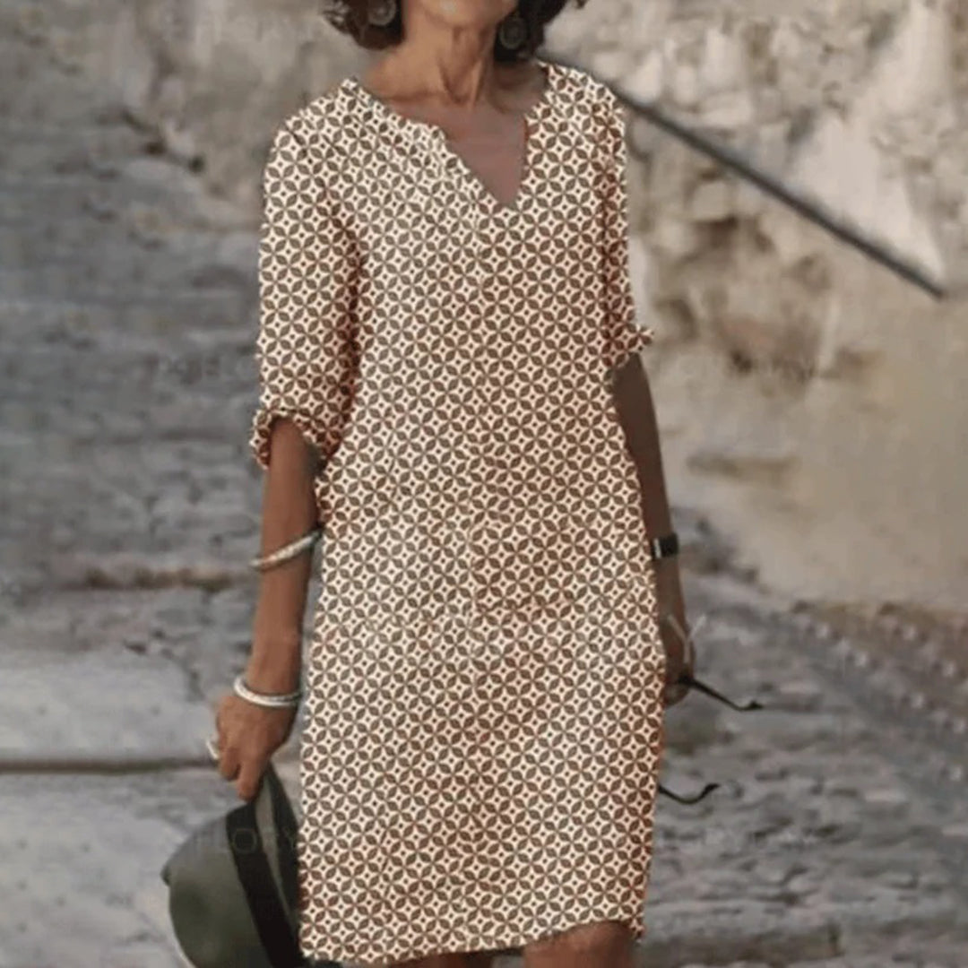 Vrouw in beige en bruine geometrische jurk, casual zomeroutfit, buiten op straat, modieuze dameskleding, trendy jurk met patroon.