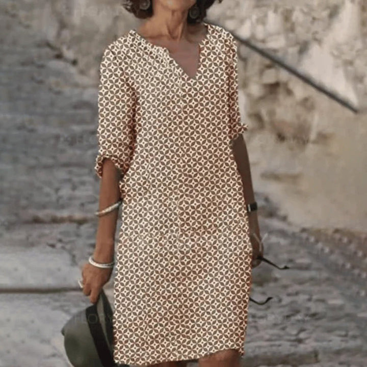 Vrouw in beige en bruine geometrische jurk, casual zomeroutfit, buiten op straat, modieuze dameskleding, trendy jurk met patroon.
