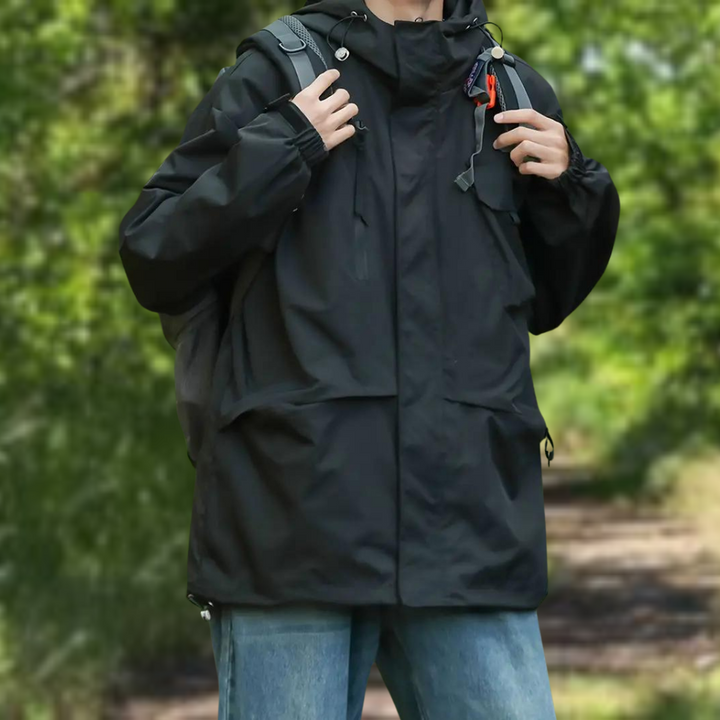 Zwarte waterdichte outdoor jas voor heren, ideaal voor wandelen en kamperen. Voorzien van capuchon en zakken. Comfortabele pasvorm voor alle weersomstandigheden.