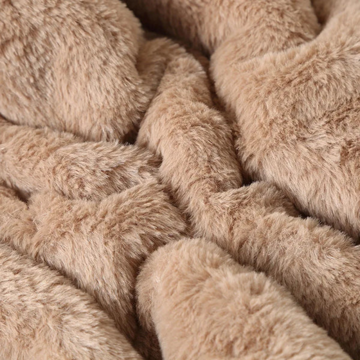 Zachte beige pluche stof close-up, ideaal voor dekens en kleding. Luxe textuur, warme uitstraling, perfect voor interieurdecoratie en mode.