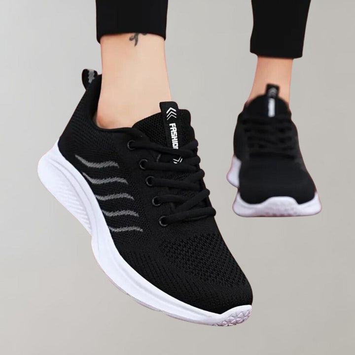 Zwarte sportschoenen met witte zool, ademend mesh bovenwerk, vetersluiting. Ideaal voor hardlopen en fitness. Comfortabele en stijlvolle sneakers.