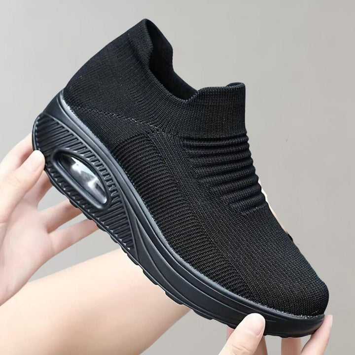 Zwarte dames sneaker met verhoogde zool, ademend gebreid bovenwerk en luchtkussen. Comfortabele, modieuze schoenen voor dagelijks gebruik.