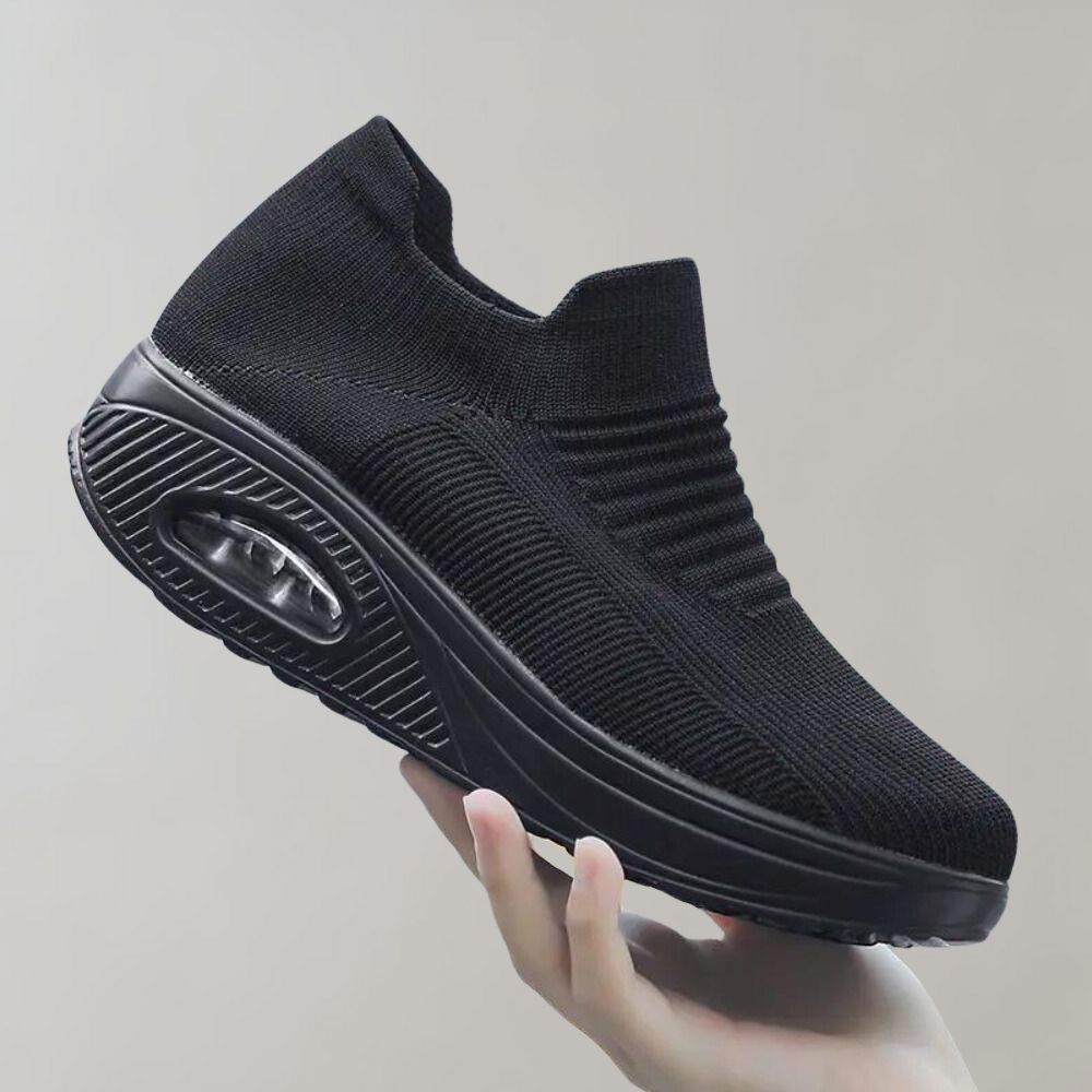 Zwarte dames sneaker met verhoogde zool, ademend mesh bovenwerk en luchtkussen, ideaal voor comfort en stijl.