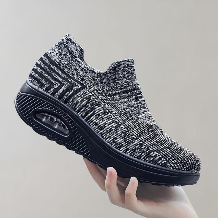 Donkergrijze gebreide sneaker met verhoogde zool en luchtkussen, comfortabel en stijlvol, ideaal voor dagelijks gebruik en wandelen.