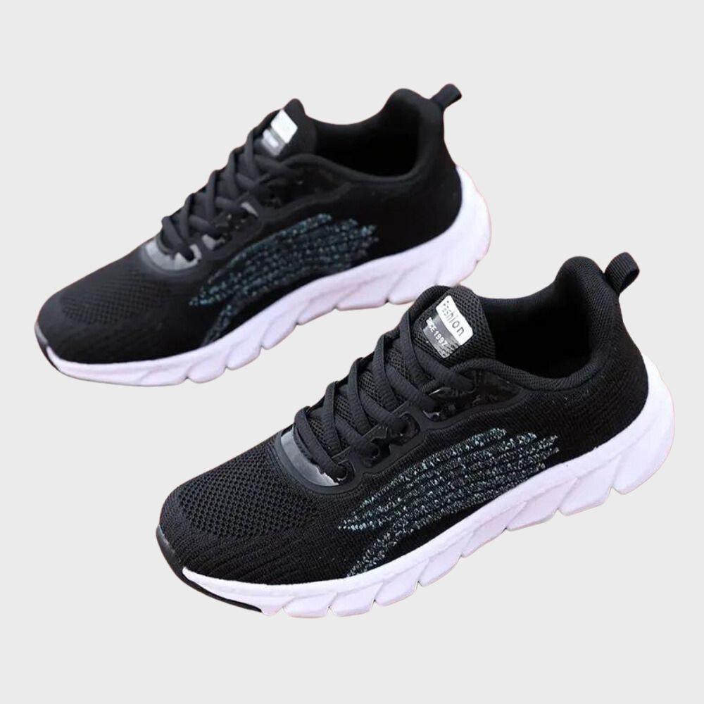 Zwarte sportschoenen met witte zool, ademend mesh bovenwerk, geschikt voor hardlopen en fitness. Comfortabele en stijlvolle sneakers voor dagelijks gebruik.