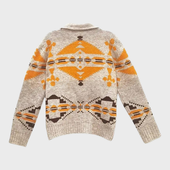 Grijze trui met oranje en bruine Azteekse print, lange mouwen, en ronde hals. Perfect voor herfstmode en casual outfits.