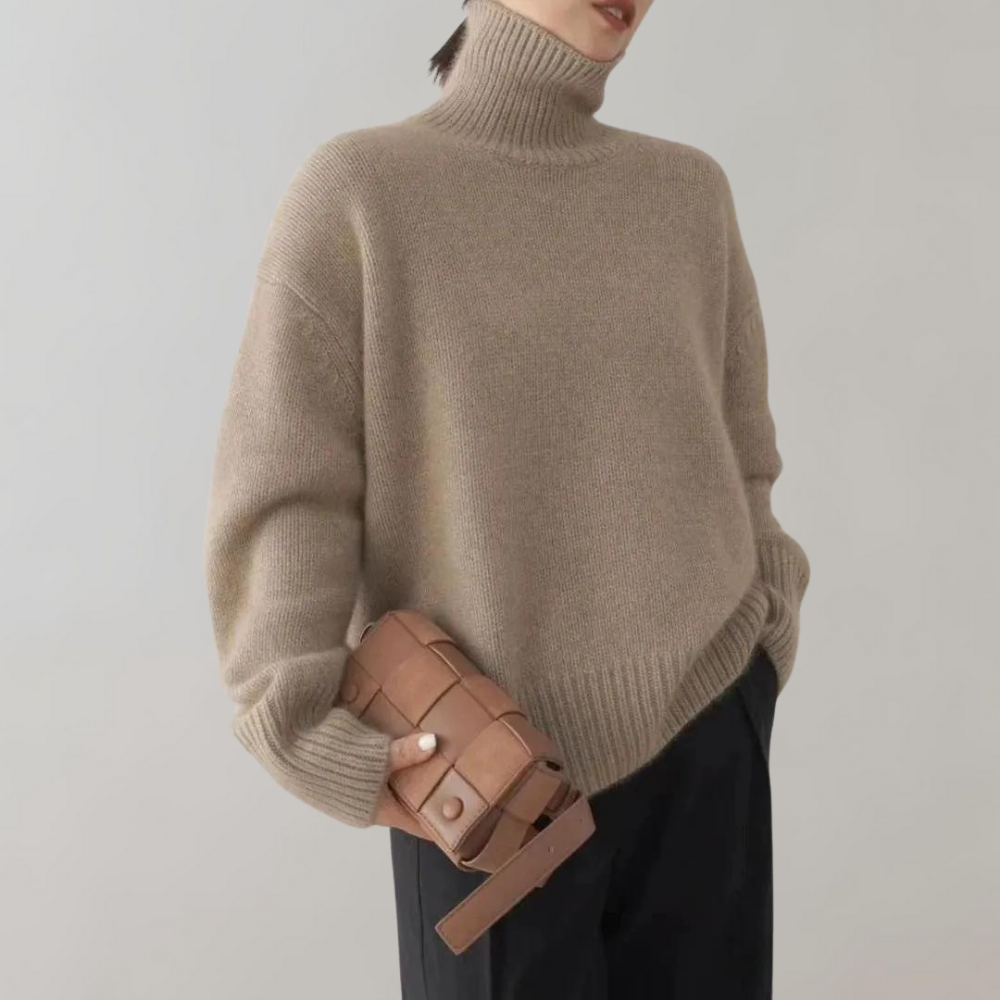 Beige oversized trui met col, gecombineerd met zwarte broek en bruine geweven leren tas. Stijlvolle herfstmode voor dames.