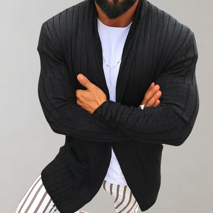 Zwarte gebreide heren cardigan, open voorkant, gedragen over een wit T-shirt. Stijlvolle herenkleding, geschikt voor casual en formele gelegenheden.