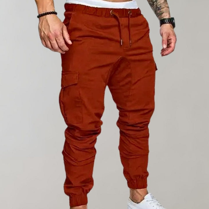 Bruine cargobroek voor heren met elastische tailleband, zijzakken en enkelboorden. Modieuze streetwear-stijl, ideaal voor casual outfits.