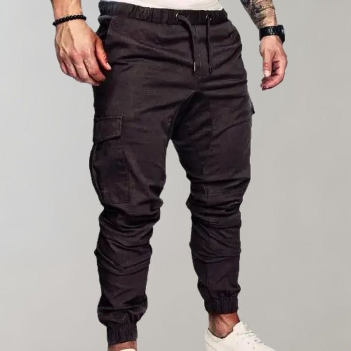 Grijze cargo joggingbroek voor heren met elastische tailleband, zijzakken en enkelboorden. Comfortabele streetwear-stijl.