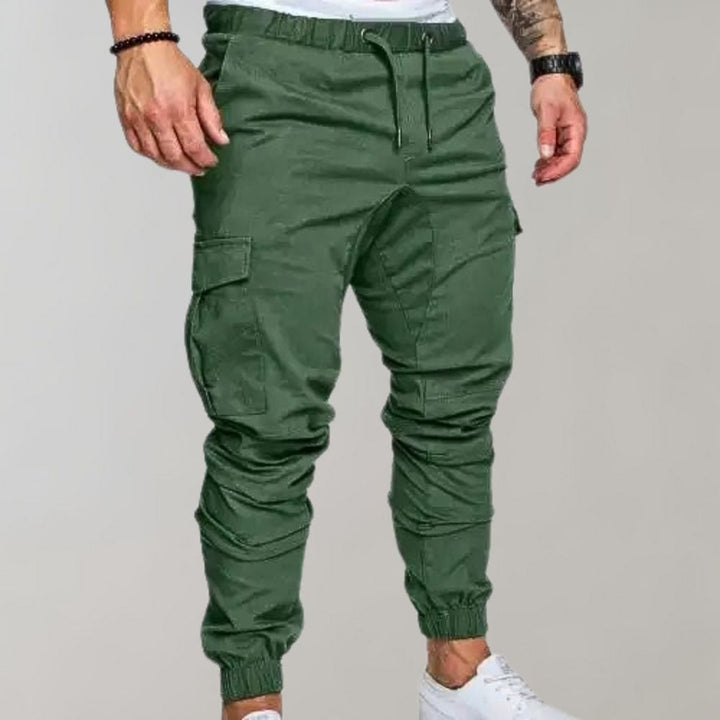 Groene cargo joggingbroek voor heren met elastische tailleband, zijzakken en enkelboorden. Comfortabele streetwear-stijl. Perfect voor casual outfits.