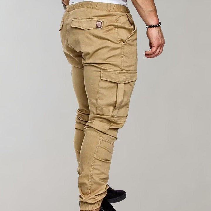 Khaki cargobroek voor heren, zijaanzicht. Comfortabele pasvorm, meerdere zakken, ideaal voor casual en outdoor activiteiten. Trendy herenkleding.
